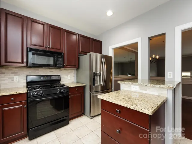 a kitchen with granite countertop wooden cabinets and stainless steel appliances