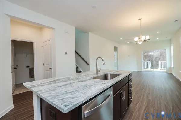 a kitchen with a sink a counter space and wooden floor