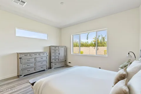 a bedroom with a bed and wooden floor