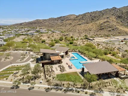a view of a patio with a table and chairs under an umbrella with a barbeque