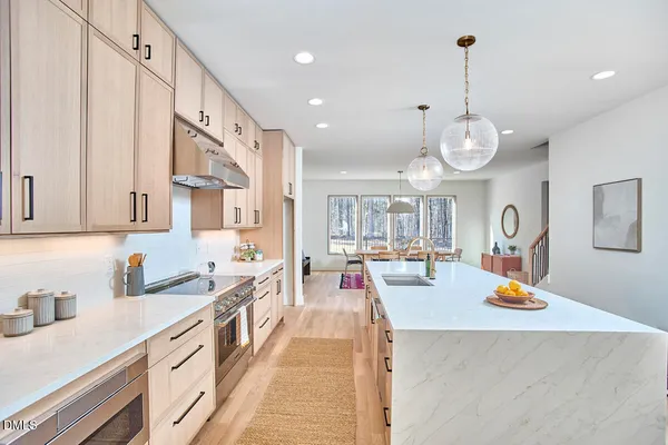 a kitchen with a sink a stove and cabinets