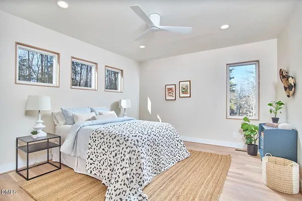 a bedroom with a bed a dresser and chair