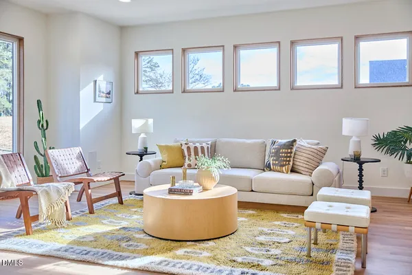 a living room with furniture and a wooden floor