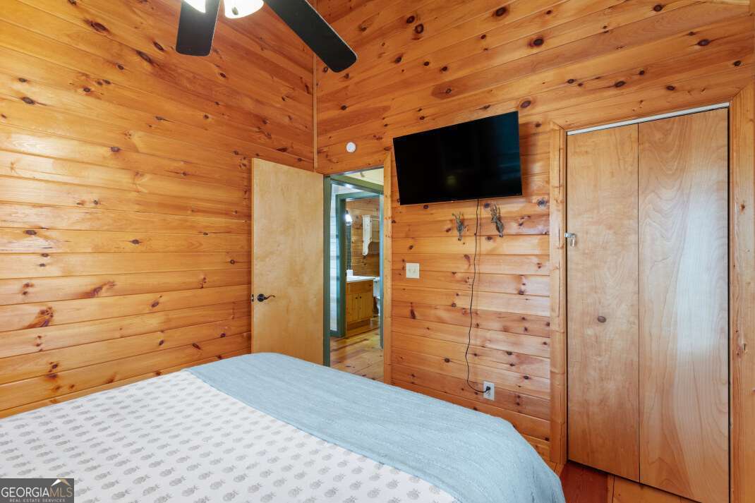 100 Smith Hill Road Blue Ridge, GA 30513 - Photo 32 of 66 a bedroom with a bed tv and wooden floor