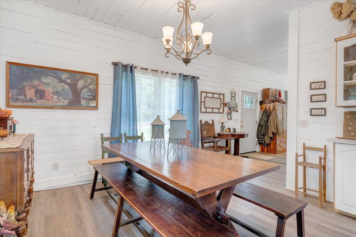 568 Moores Mill Road Ridgeway, VA 24148 - Photo 32 of 51 a dining room with wooden floor a chandelier a wooden table and chairs