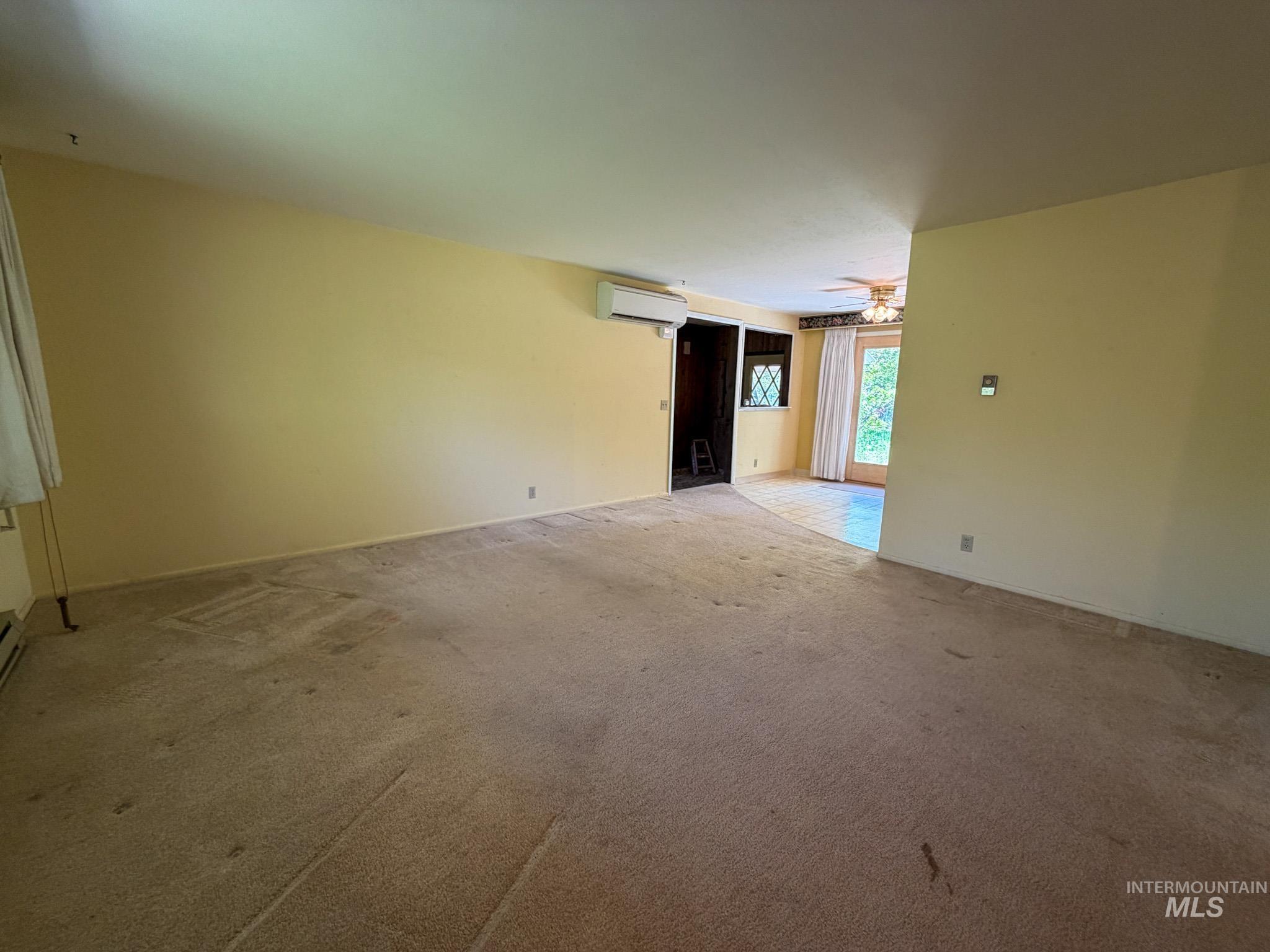 1924 H Street Rupert, ID 83350 - Photo 2 of 13 Spacious interior with neutral-toned walls, carpeted flooring, and a ceiling fan