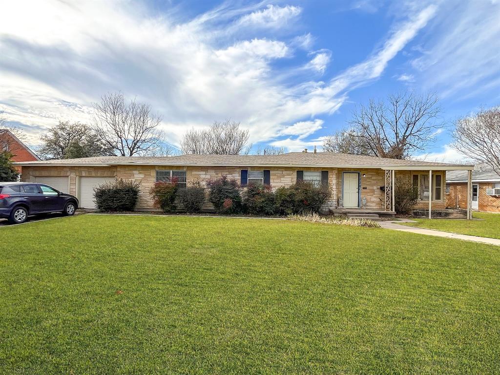 a front view of a house with a garden and lake view
