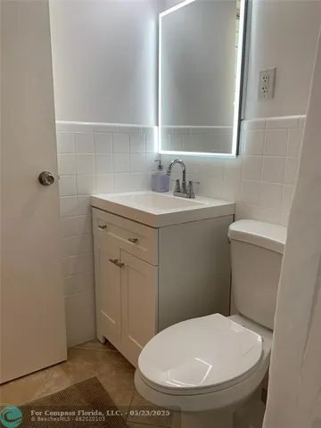 a living room with furniture a kitchen view and a refrigerator