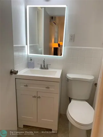 a living room with furniture wooden floor and kitchen view