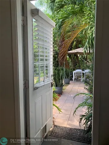 a view of a yard with plants and trees