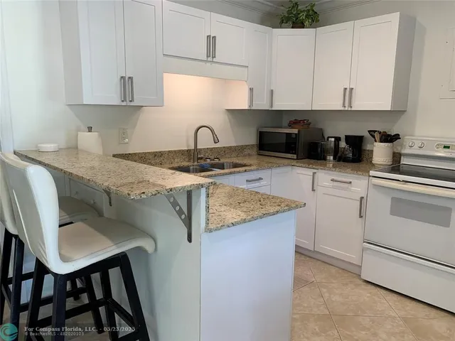 a bedroom with a bed two lamps and a large window