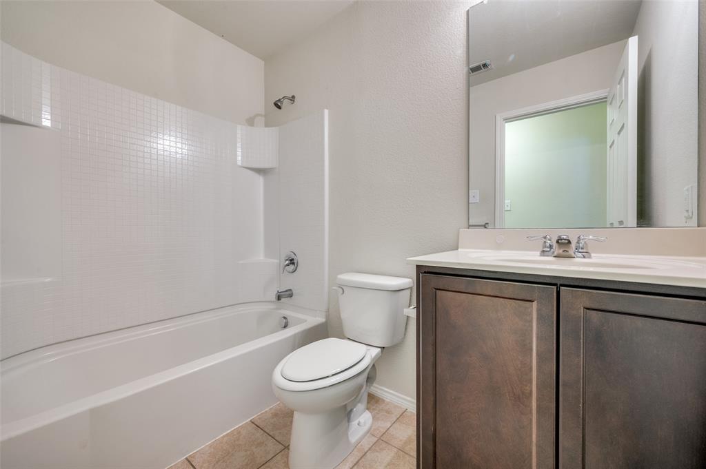 1420 Rivers Creek Lane Little Elm, TX 75068 - Photo 14 of 25 a bathroom with a toilet a sink a mirror a bathtub and vanity