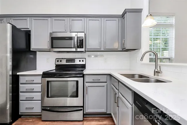 a kitchen with white cabinets stainless steel appliances and sink