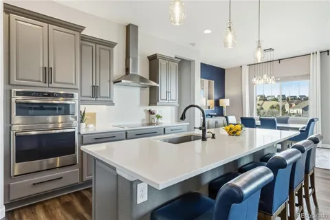 a kitchen with granite countertop a sink stove and refrigerator