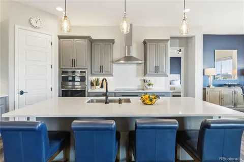 a kitchen with a sink a stove and chairs