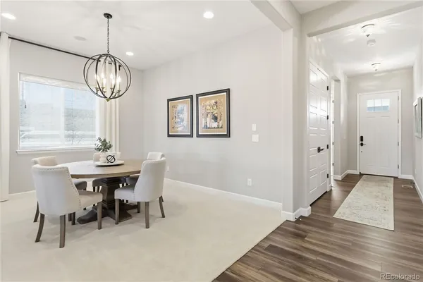 a view of a dining room with furniture wooden floor and chandelier