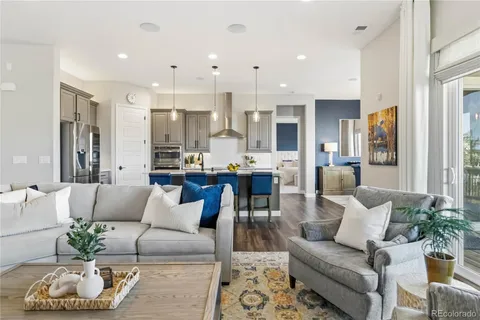 a living room with furniture kitchen and a large window