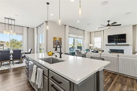 a open kitchen with stainless steel appliances granite countertop a sink a stove and a living room view