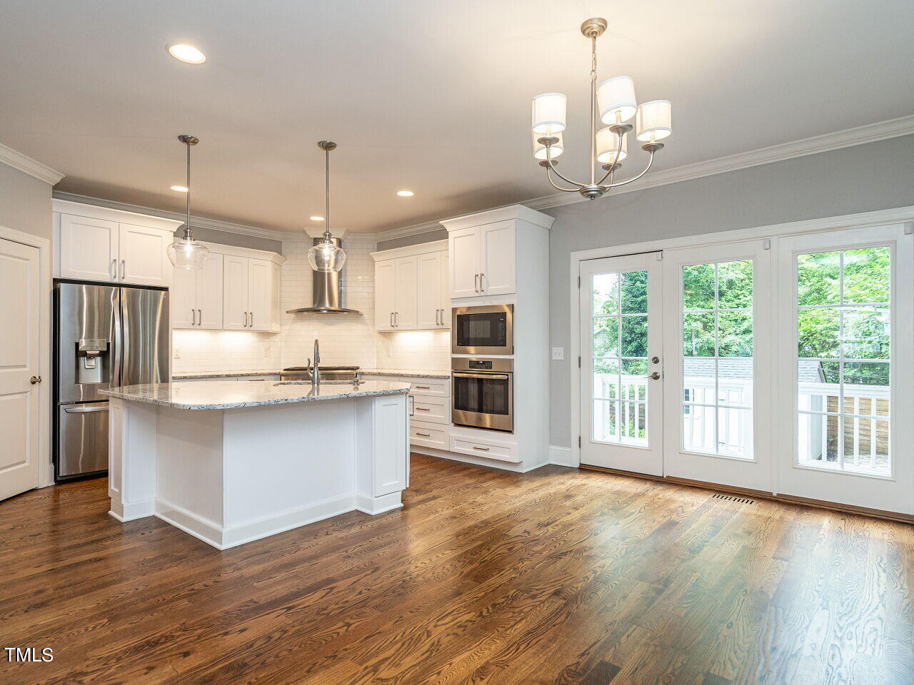1506 East Jones Street Raleigh, NC 27610 - Photo 8 of 35 a kitchen with stainless steel appliances granite countertop a refrigerator oven a sink dishwasher a dining table and chairs with wooden floor