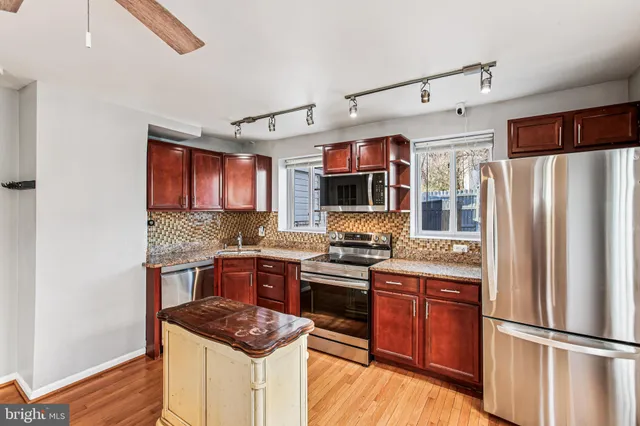 a kitchen with stainless steel appliances granite countertop a refrigerator a stove top oven a sink and dishwasher
