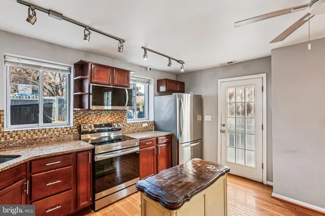 a kitchen with stainless steel appliances granite countertop a refrigerator stove and sink