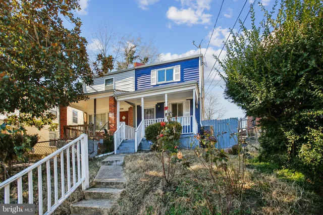 a view of a house with brick walls and a tree