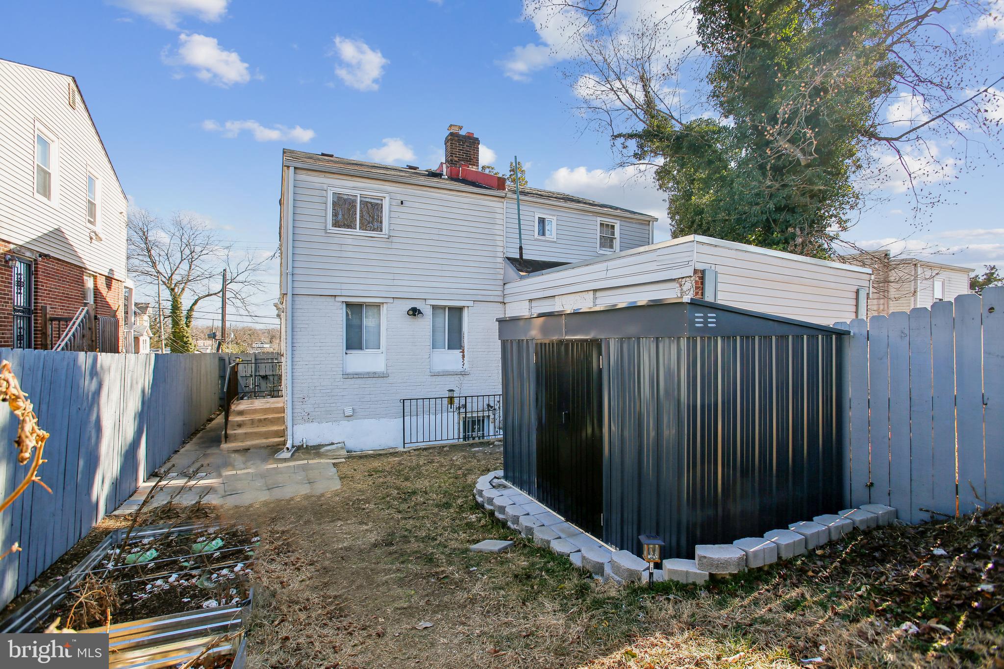 836 Division Avenue Northeast Washington, DC 20019 - Photo 29 of 36 a view of a house with a small yard and wooden fence