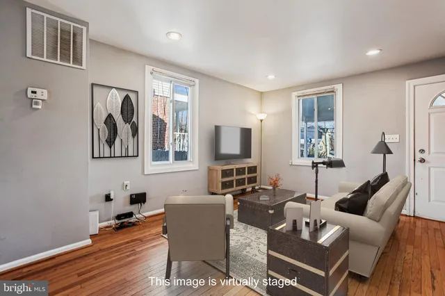 a living room with furniture a flat screen tv and a window
