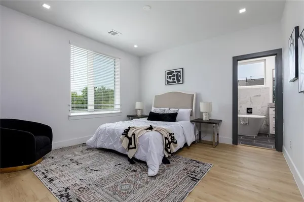 a bedroom with a bed and wooden floor