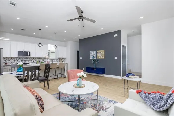 a large white kitchen with lots of counter space wooden floor and appliances