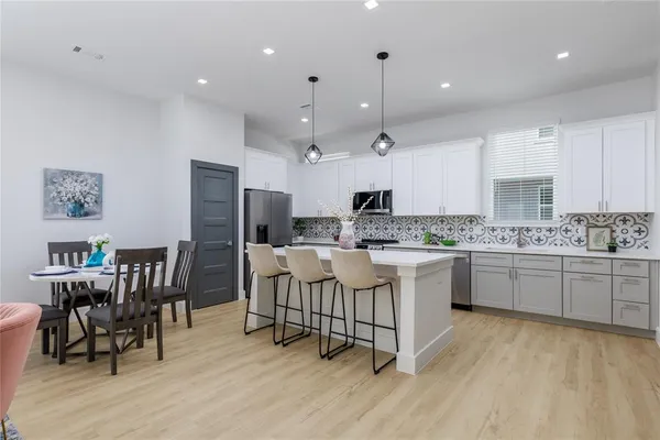a kitchen with a refrigerator and white cabinets
