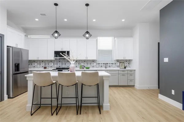 a kitchen with a sink a stove a refrigerator and a cabinets