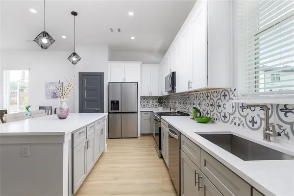 a kitchen with cabinets appliances and a sink