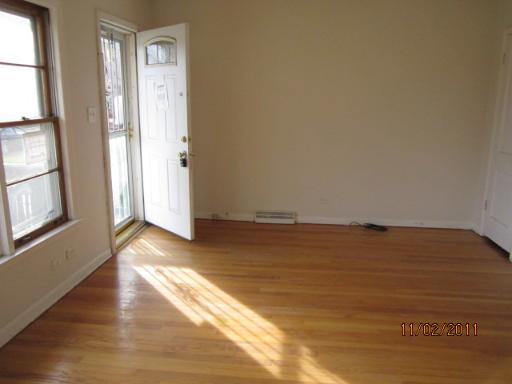 7418 West 63rd Place Summit, IL 60501 - Photo 3 of 9 a view of empty room with wooden floor and fan
