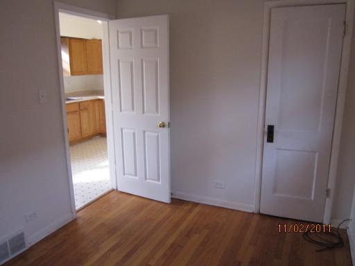 7418 West 63rd Place Summit, IL 60501 - Photo 5 of 9 an empty room with wooden floor and closet