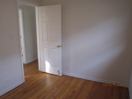 7418 West 63rd Place Summit, IL 60501 - Photo 6 of 9 a view of an empty room with wooden floor