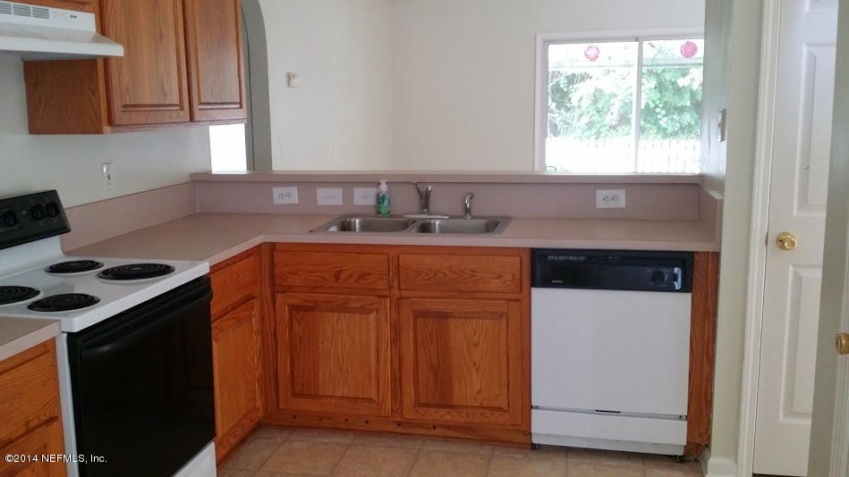2750 Archer Street Middleburg, FL 32068 - Photo 5 of 34 a kitchen with granite countertop a sink stove and cabinets