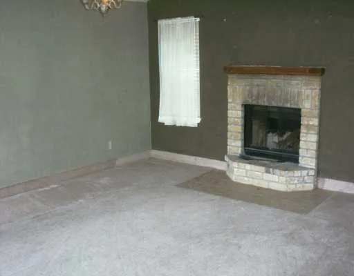 a view of empty room with a fireplace