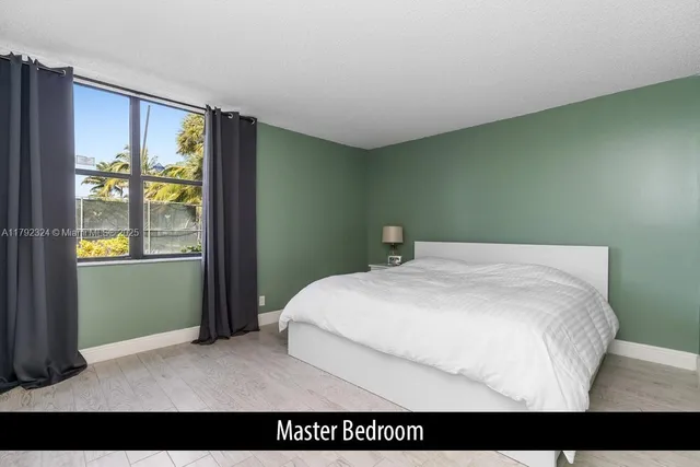 a bedroom with a bed and a painting on the wall