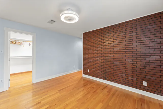 a view of a bedroom with a ceiling fan and a window