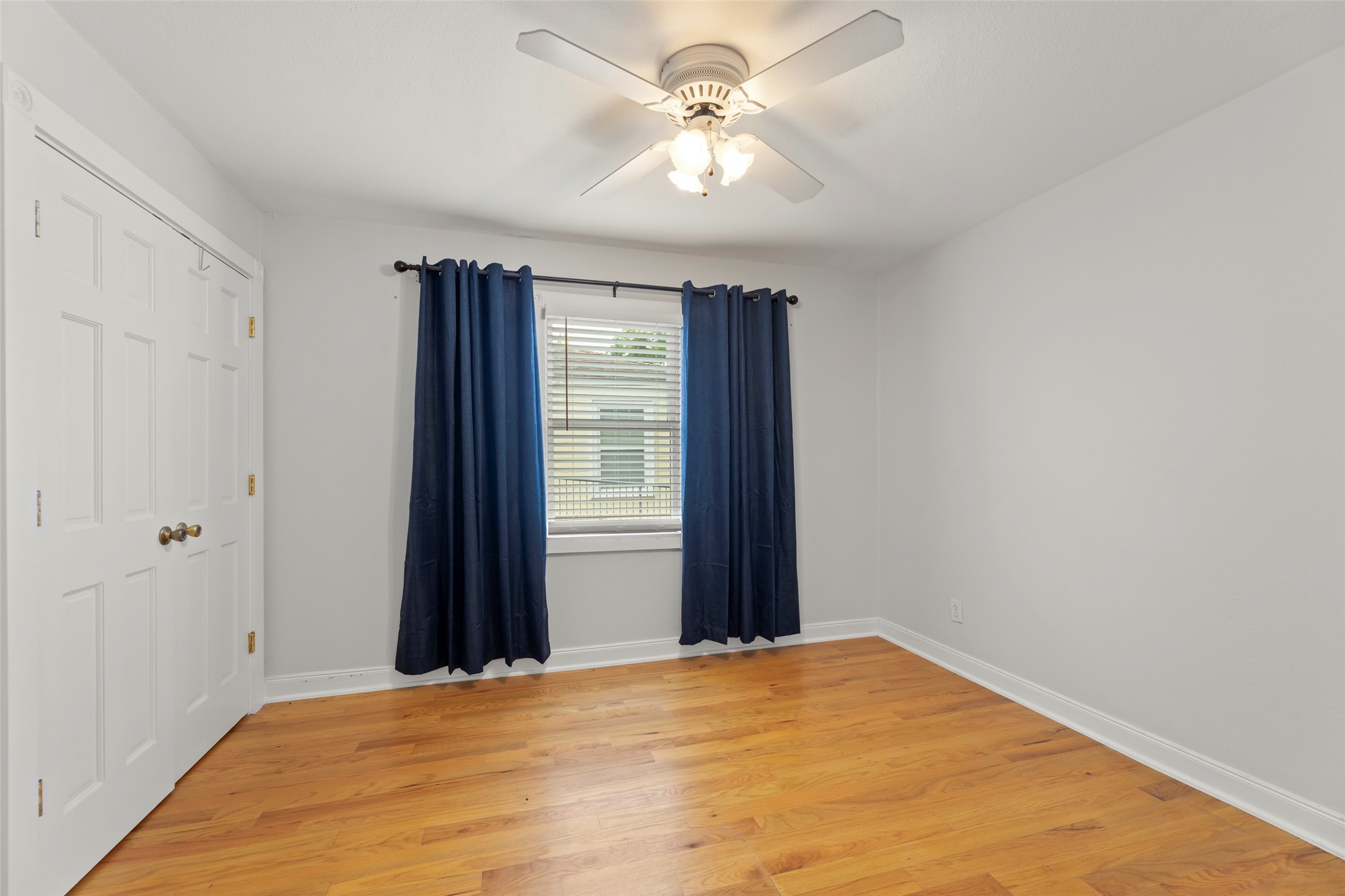 2209 Portsmouth Street Houston, TX 77098 - Photo 22 of 28 a view of a bedroom with a ceiling fan and a window