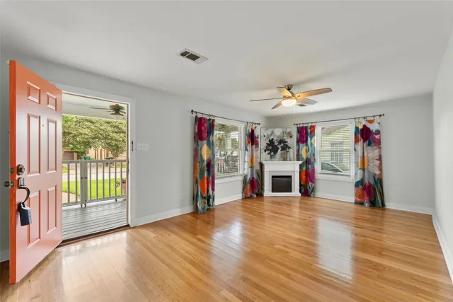 a view of a livingroom with wooden floor and stairs