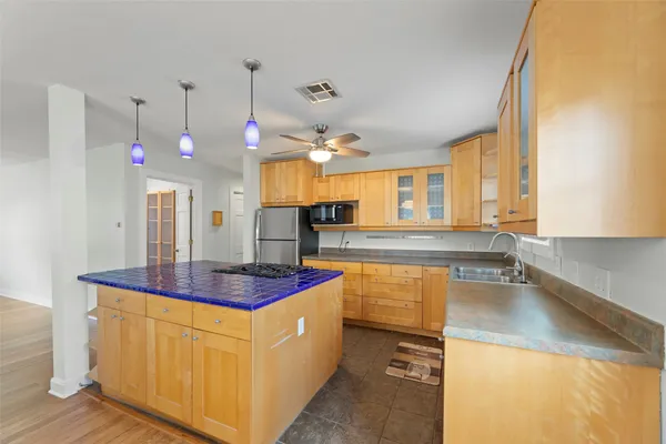 a kitchen with stainless steel appliances granite countertop a sink a stove and a refrigerator