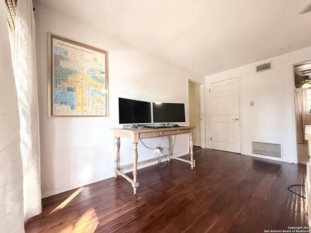a view of a livingroom with wooden floor and a flat screen tv