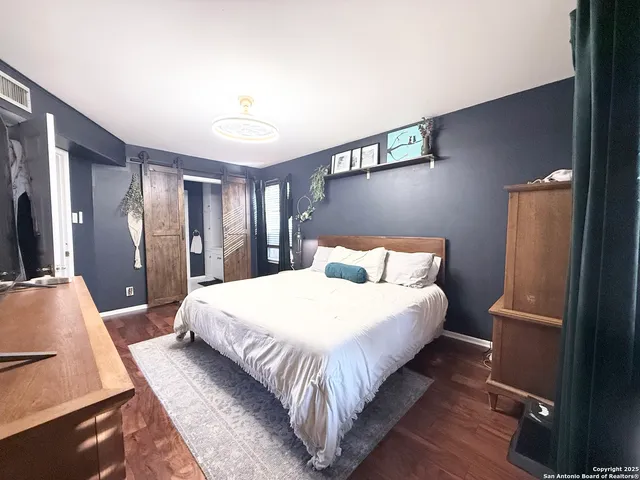 a large bed sitting in a bedroom next to a window