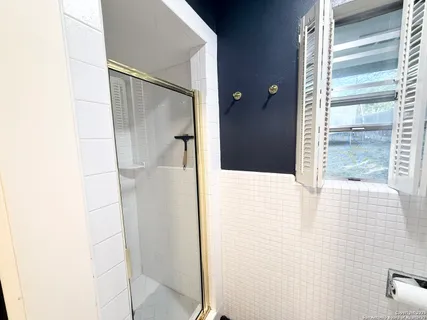 a bathroom with a shower and a mirror