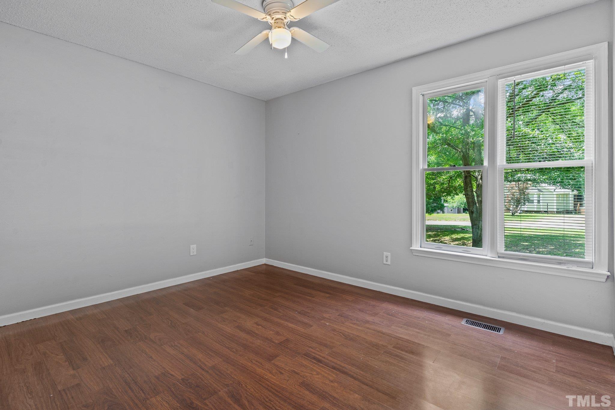 4209 Rockside Hills Drive Raleigh, NC 27603 - Photo 14 of 24 a view of an empty room with wooden floor and a window