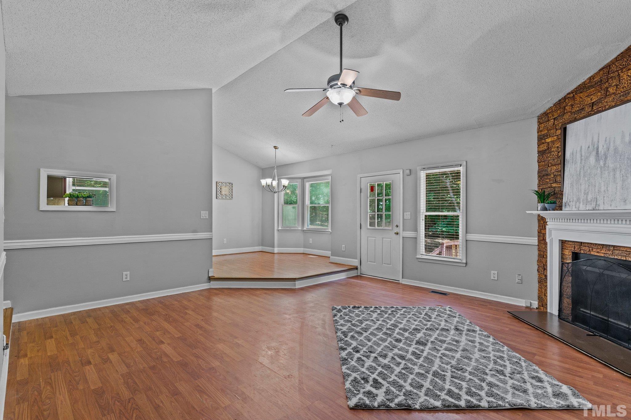 4209 Rockside Hills Drive Raleigh, NC 27603 - Photo 5 of 24 a living room with a fireplace and chandelier