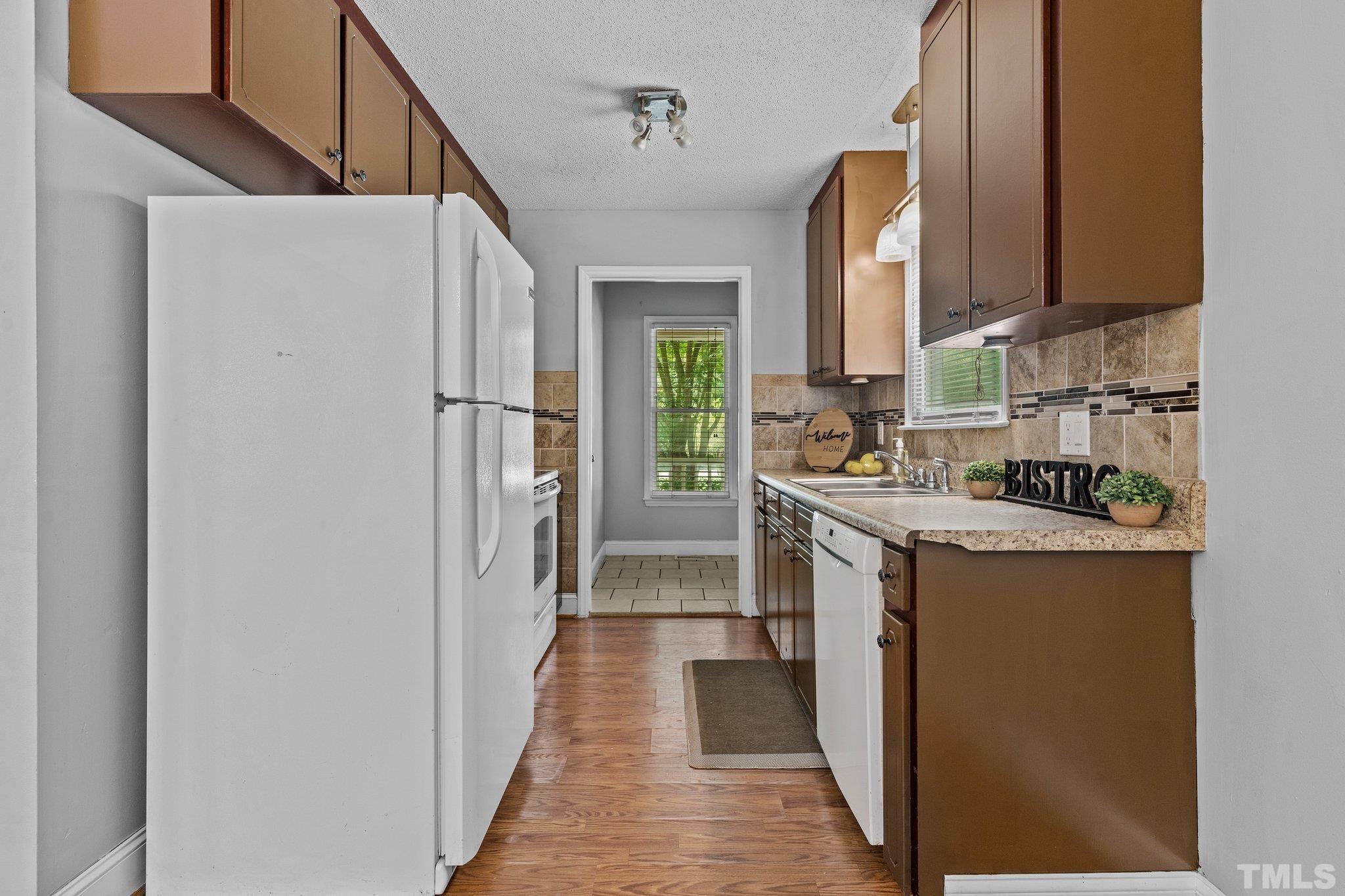 4209 Rockside Hills Drive Raleigh, NC 27603 - Photo 8 of 24 a kitchen with a refrigerator a stove top oven a sink and dishwasher