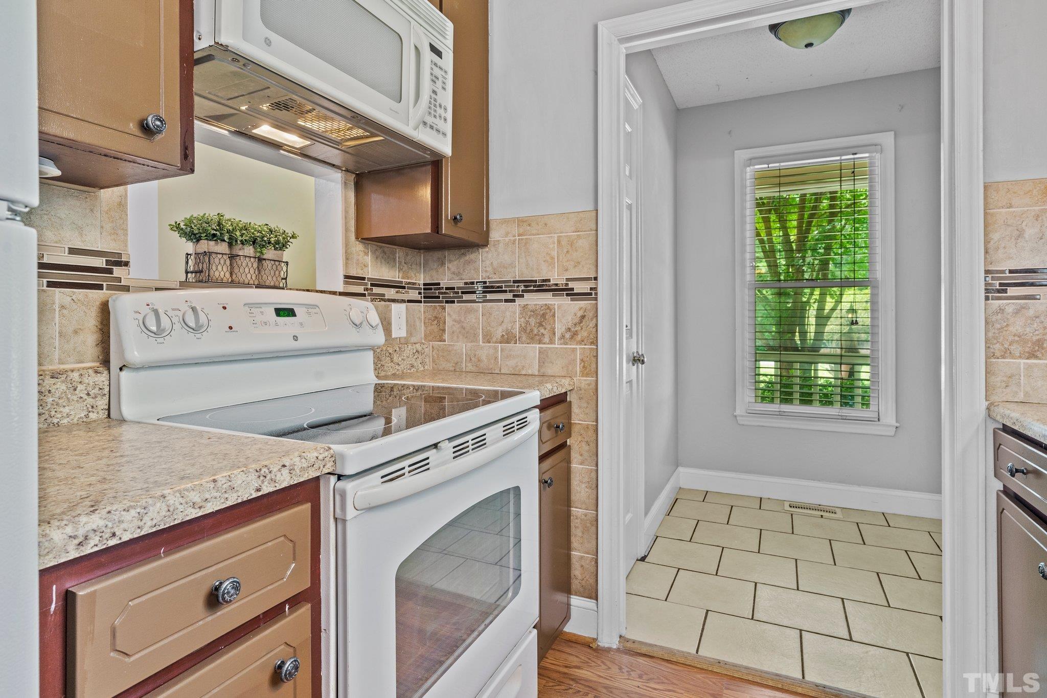 4209 Rockside Hills Drive Raleigh, NC 27603 - Photo 10 of 24 a kitchen with granite countertop white cabinets and white appliances